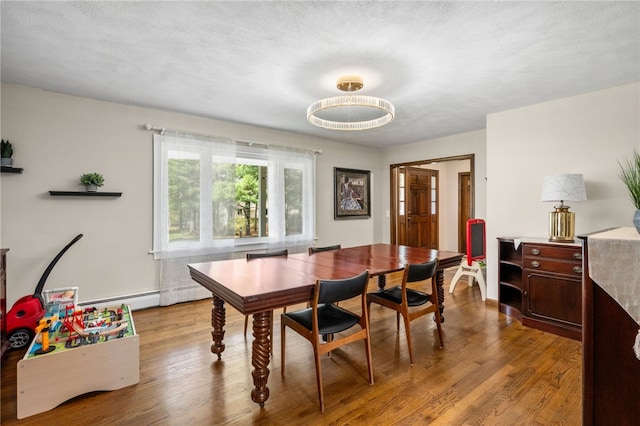 dining space with a baseboard radiator and wood finished floors
