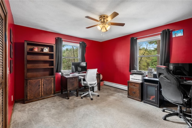 carpeted office space with baseboard heating, baseboards, and ceiling fan