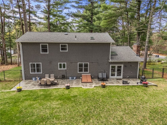 back of house featuring a chimney, a patio area, a yard, and a fenced backyard