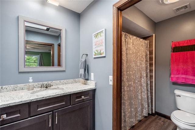 bathroom with wood finished floors, vanity, a shower with curtain, toilet, and visible vents