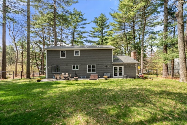 back of house featuring a lawn, a patio, a fenced backyard, and french doors