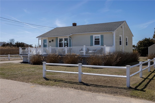 single story home with a chimney, a front lawn, a shingled roof, and fence private yard