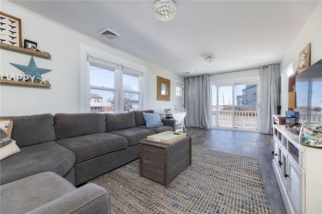 living area with visible vents, wood finished floors, and a notable chandelier
