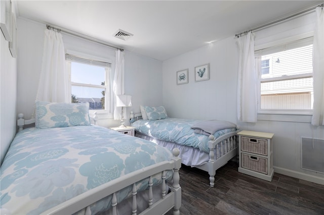 bedroom featuring multiple windows, baseboards, visible vents, and dark wood finished floors