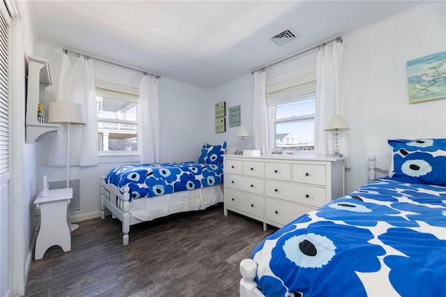 bedroom featuring visible vents, dark wood-type flooring, and multiple windows