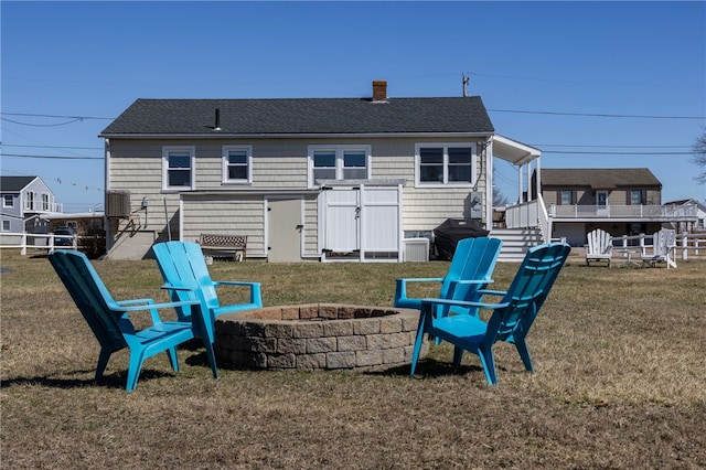 back of house with a chimney, stairs, a yard, cooling unit, and an outdoor fire pit