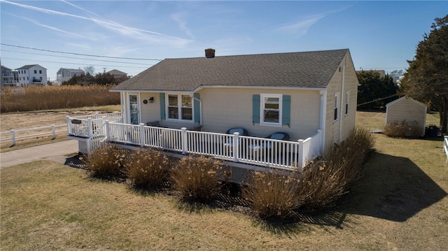back of property featuring fence, a lawn, and roof with shingles