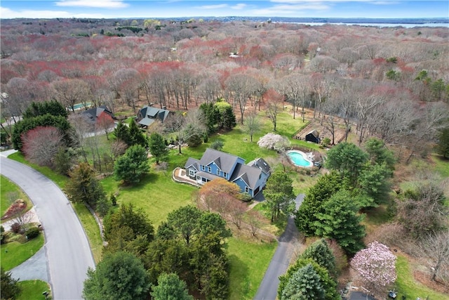 aerial view of property and surrounding area with a heavily wooded area