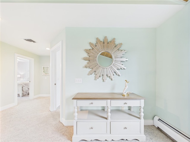 hall with a baseboard heating unit, baseboards, and carpet flooring