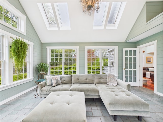 sunroom / solarium with vaulted ceiling, plenty of natural light, a skylight, and french doors