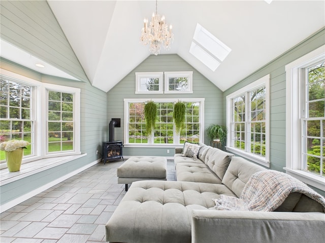 sunroom / solarium featuring lofted ceiling, a wood stove, healthy amount of natural light, a skylight, and a chandelier