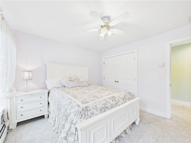 bedroom with light colored carpet, a closet, a ceiling fan, and baseboards