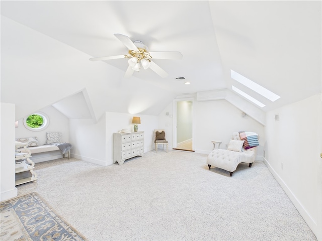carpeted bedroom with vaulted ceiling, a skylight, a ceiling fan, and baseboards