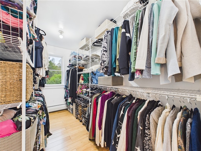 spacious closet featuring wood finished floors and baseboard heating