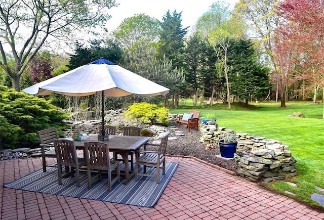view of patio / terrace featuring outdoor dining space and view of scattered trees