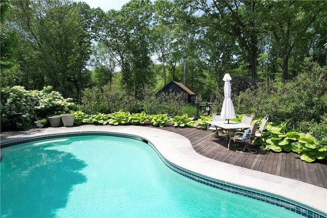 50 Intrepid Ln, Jamestown, RI 02835 - swimming pool featuring a deck, view of scattered trees, and outdoor dining area