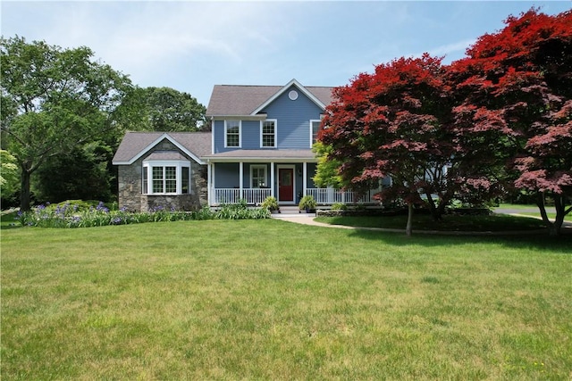 50 Intrepid Ln, Jamestown, RI 02835 - view of front of property featuring covered porch, stone siding, and a front yard