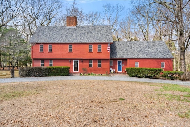 view of front of property featuring a front yard, entry steps, and a chimney