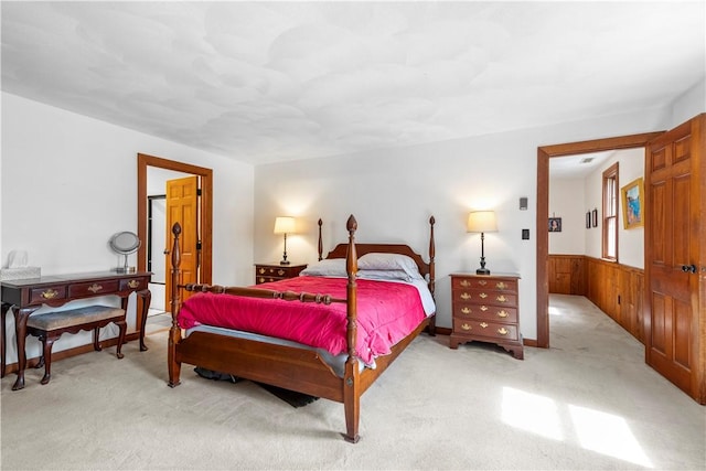 bedroom featuring a wainscoted wall, wooden walls, and carpet floors