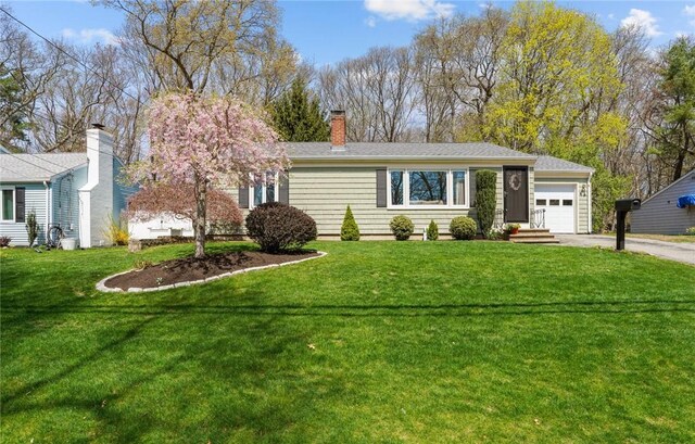 ranch-style house featuring an attached garage, a front lawn, aphalt driveway, and a chimney