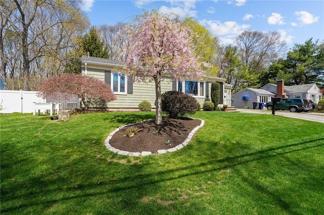 ranch-style house with fence and a front yard