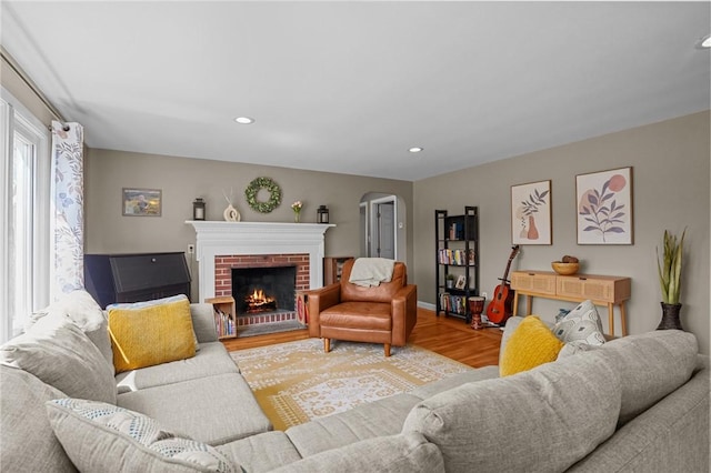 living area with a fireplace, wood finished floors, baseboards, and recessed lighting