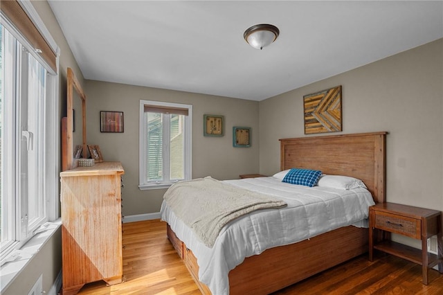 bedroom with light wood finished floors and baseboards