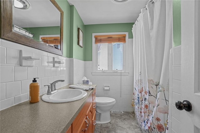 bathroom with tile walls, a shower with curtain, vanity, and toilet
