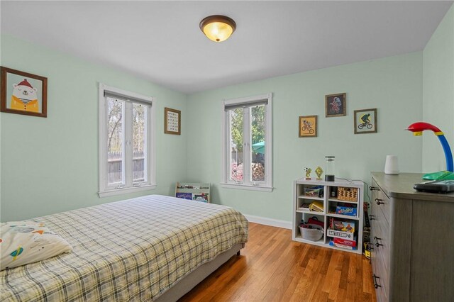 bedroom with baseboards and wood finished floors