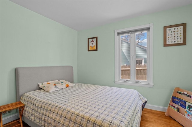 bedroom featuring baseboards and wood finished floors