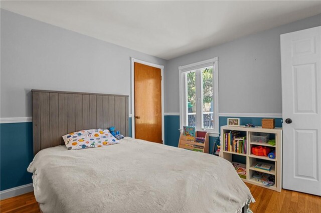 bedroom featuring baseboards and wood finished floors
