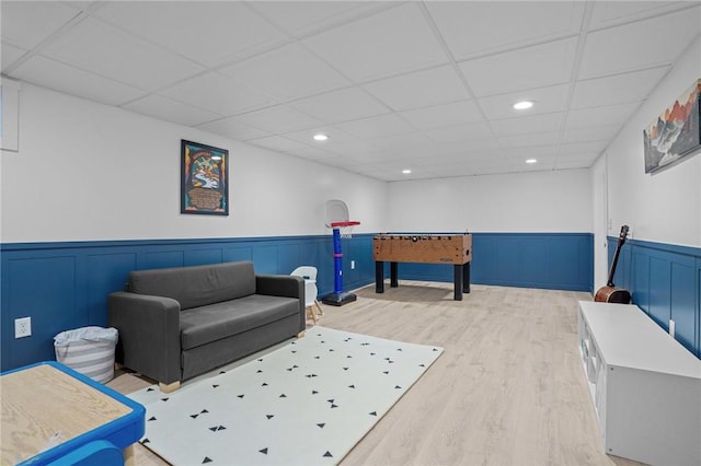rec room featuring wainscoting, wood finished floors, recessed lighting, and a drop ceiling