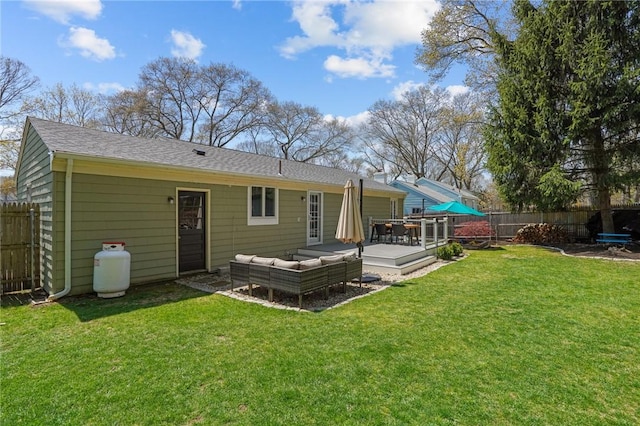 rear view of property featuring a fenced backyard, a wooden deck, outdoor lounge area, a lawn, and a shingled roof