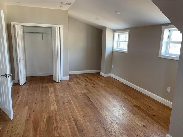 88 Reed St, Warwick, RI 02886 - unfurnished bedroom featuring light wood-style floors, lofted ceiling, and a closet