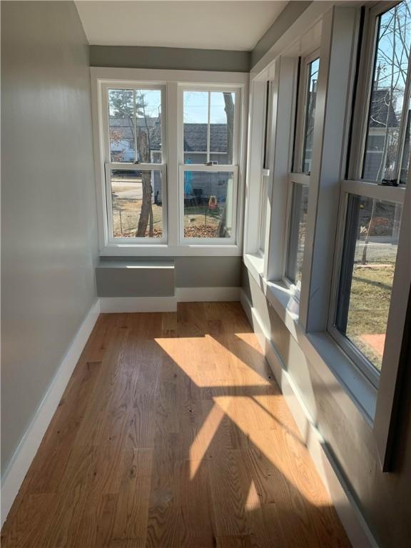88 Reed St, Warwick, RI 02886 - unfurnished sunroom with baseboards and wood finished floors