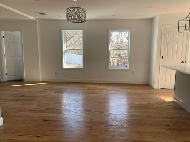 88 Reed St, Warwick, RI 02886 - unfurnished dining area with plenty of natural light, wood finished floors, and a chandelier