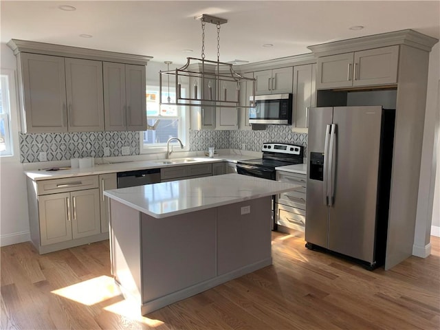 88 Reed St, Warwick, RI 02886 - kitchen with stainless steel appliances, gray cabinets, healthy amount of natural light, and a kitchen island