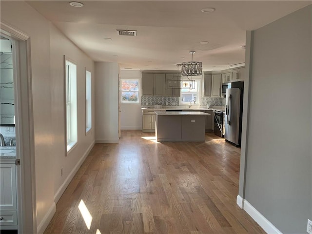 88 Reed St, Warwick, RI 02886 - kitchen featuring appliances with stainless steel finishes, a kitchen island, light countertops, light wood-style flooring, and recessed lighting
