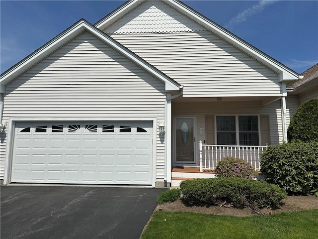 view of front of home featuring a porch, driveway, and a garage