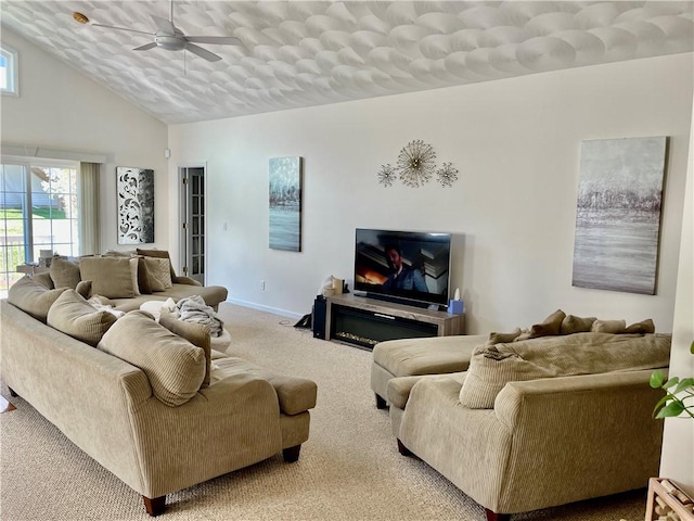 living room with high vaulted ceiling, ceiling fan, baseboards, and carpet flooring
