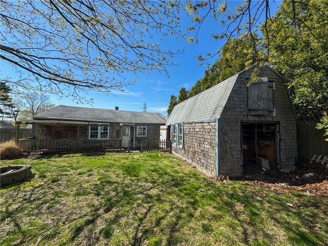 8 Tucker Ave, Tiverton, RI 02878 - back of property featuring a lawn, an outbuilding, and fence