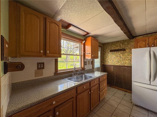 8 Tucker Ave, Tiverton, RI 02878 - kitchen with freestanding refrigerator, brown cabinetry, and a sink