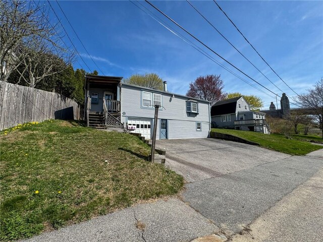 8 Tucker Ave, Tiverton, RI 02878 - view of front of home featuring fence, a front lawn, driveway, and a garage