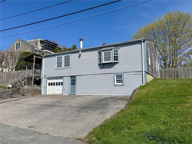 8 Tucker Ave, Tiverton, RI 02878 - rear view of property with a chimney, aphalt driveway, fence, an attached garage, and a lawn