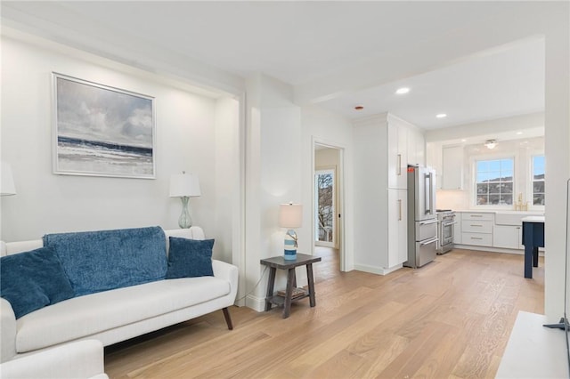 living room with light wood-type flooring, baseboards, and recessed lighting