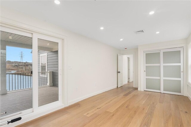 empty room with recessed lighting, light wood-style flooring, visible vents, and baseboards