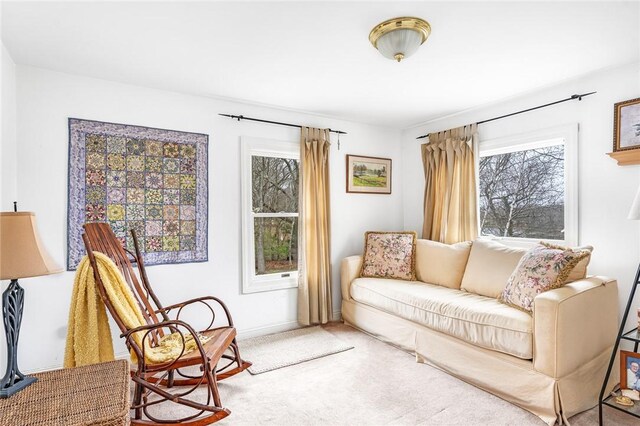 sitting room featuring carpet floors, plenty of natural light, and baseboards