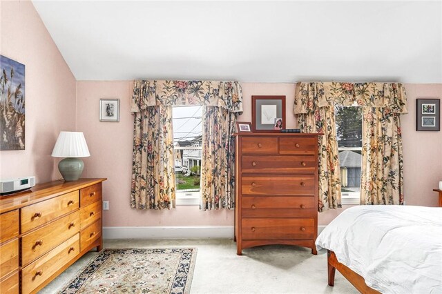 bedroom with baseboards and light carpet