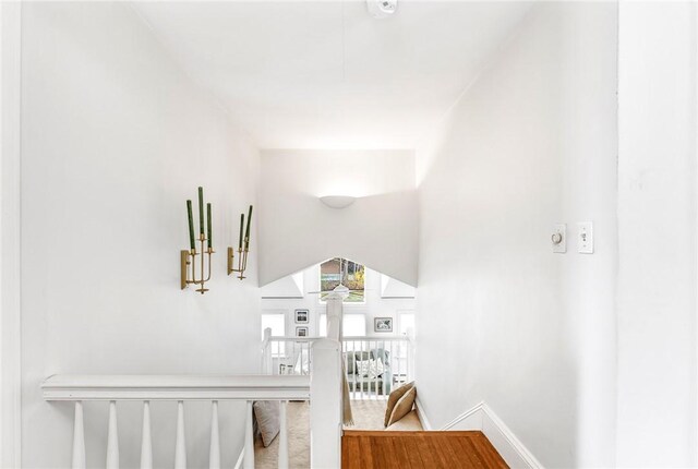 hall with baseboards and an upstairs landing