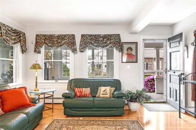 interior space with a baseboard heating unit and wood finished floors